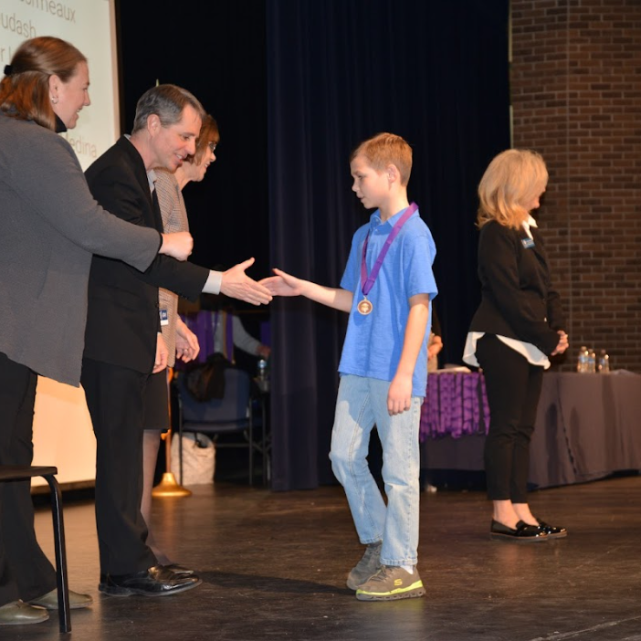 Student shakes hands of School Board members